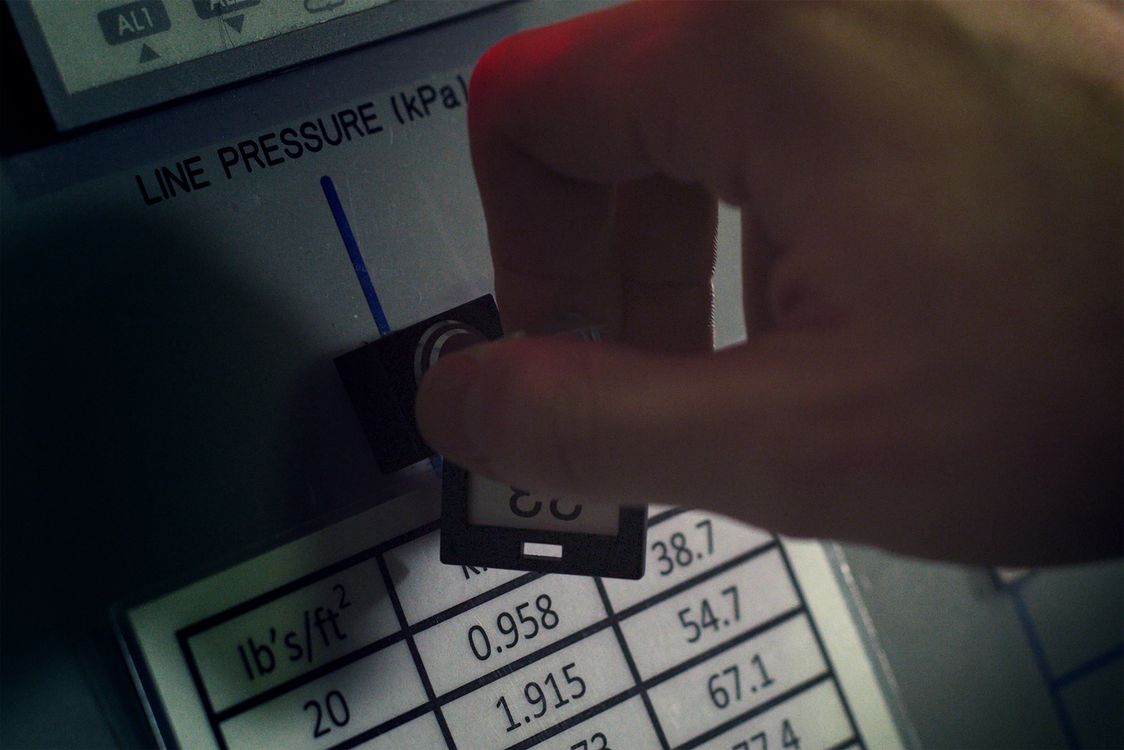 Hand die een industriële drukmeter aflezen tijdens een controle