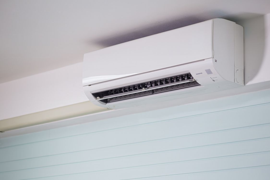 Wand-gemonteerde split-unit airco hoog aan de muur in een lichte woonkamer in Tilburg