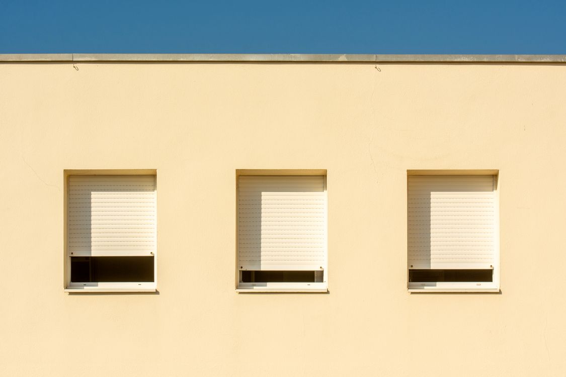 Gesloten witte zonwering houdt de felle zon buiten bij een woonhuis