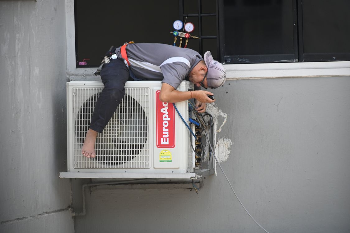 Airco-monteur controleert de buitenunit van een split-airco bij een woning in Tilburg