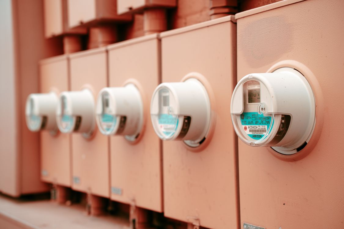 Rij stroommeters op een muur als symbool voor energiekosten en tarieven